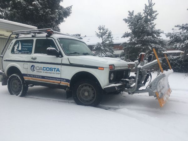 DACOSTA-Fahrzeug mit Schneepflug in einer verschneiten Umgebung.